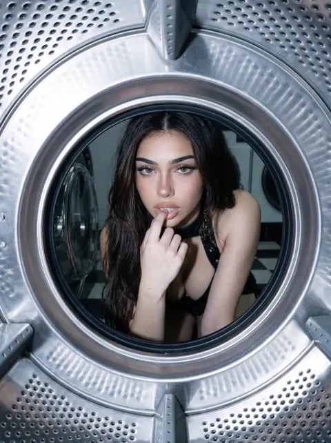 Eliza looking through a washing machine door